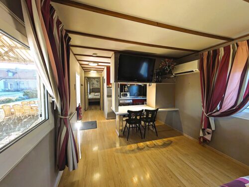 Chalet, avec le lit, la climatisation la télé et le salon.