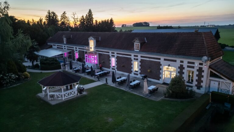 Vue aérienne de nuit de la salle de reception, le gite de la piscine, et la cuisine.